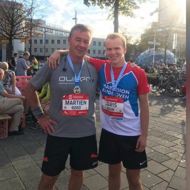 Joris after the Eindhoven half marathon, standing with his medal.